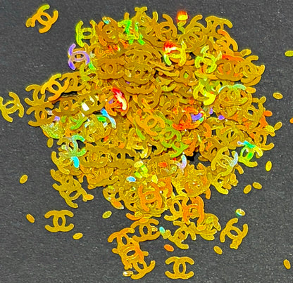Gold Chanel glitter shapes/confetti on black background