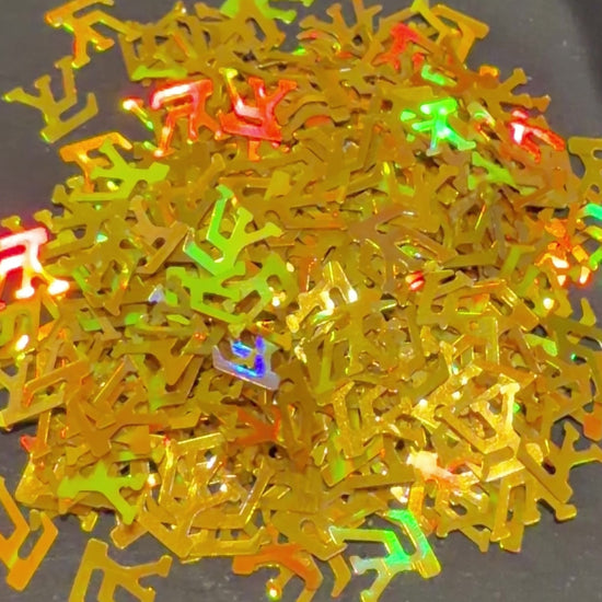 Video of holographic gold LV shaped glitter confetti falling on black background